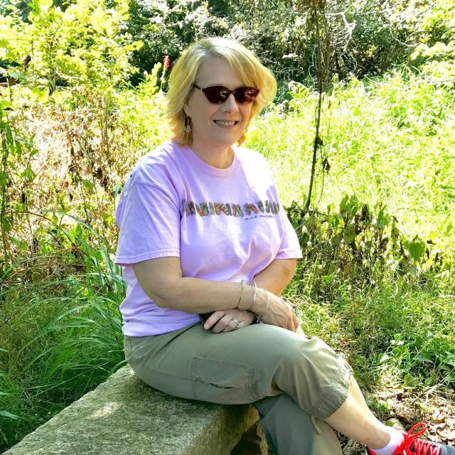 Gretchen, looking beautiful, sitting on a bench in an Asheville park, August 2019. One of my favorite pics of G.